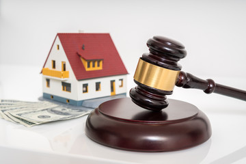 House auction concept. Gavel in front of model of house. - obrazy, fototapety, plakaty