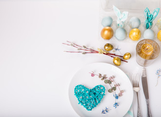 Easter table setting with gold and blue eggs and cutlery. Holidays background.