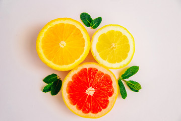 Fototapeta na wymiar Slice of lemon, grapefruit, orange and mint leaves on a white background. Top feed