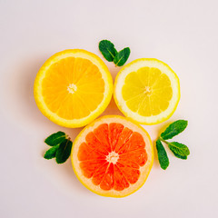 Cut lemon, grapefruit, orange and mint leaves. Bright summer background. Top feed