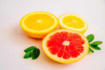 Citrus fruits on a white background. Grapefruit, lemon and orange in a cut. Side view