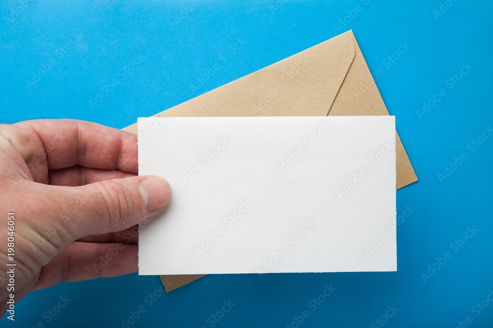 Aufkleber mock-up of a letter in hand on the background of an envelope.