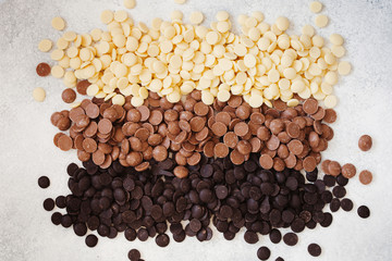 An assortment of fine white, dark, and milk chocolate in drops top view