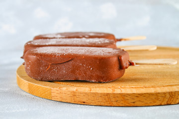 Ice cream on ice on a wooden board on a gray table. Eskimo.