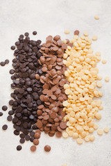 An assortment of fine white, dark, and milk chocolate in drops top view