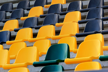 Fototapeta premium Rows of plastic black and yellow seats at a stadium