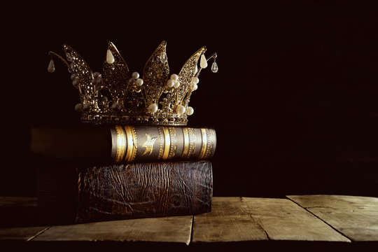 low key image of beautiful queen/king crown on old books. fantasy medieval period. Selective focus.