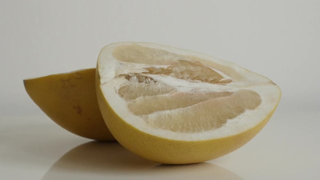  Pieces of pomello fruit on white close-up footage - Two halves of Citrus maxima grandis