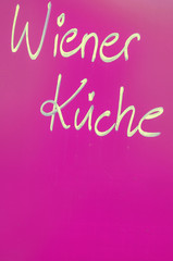 Vienna kitchen lettering against blue background