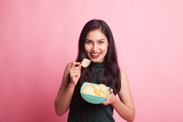 Young Asian woman eat potato chips.