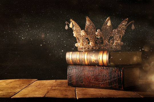 low key image of beautiful queen/king crown on old books. fantasy medieval period. Selective focus.