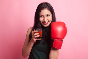 Young Asian woman with tomato juice and boxing glove.