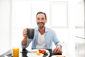Satisfied mature man drinking coffee