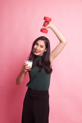 Healthy Asian woman drinking a glass of milk and dumbbell.