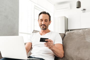 Smiling mature man using laptop computer