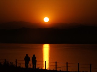 オレンジ色の太陽とカメラマンのシルエット