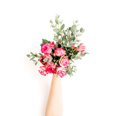 Flatlay of female hand hold rose flowers and eucalyptus bouquet on white background. Flat lay, top view spring blog hero header background.