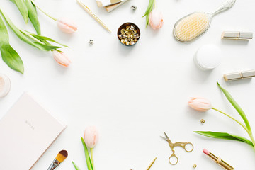 Frame of pink tulip flowers, accessories and cosmetics. Women home office desk mockup. Flat lay, top view hero header background.