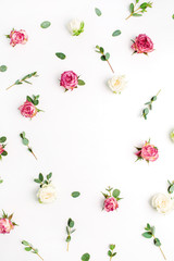 Floral frame of rose flowers and eucalyptus branches on white background. Flat lay, top view festive flowers mockup with copy space.