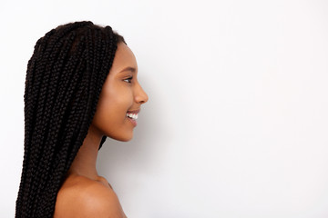 Side portrait of smiling african young woman with braids on white background - obrazy, fototapety, plakaty
