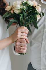 Hands with ring holding wedding bouquet