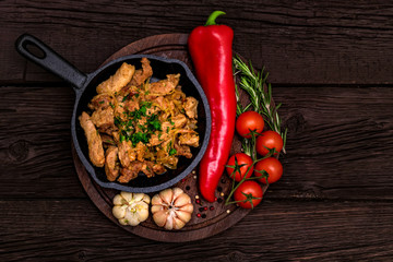 Fried pork in frying pan and vegetables