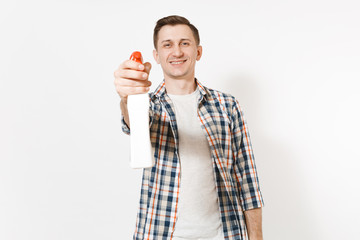 Young housekeeper man in checkered shirt holding white blank empty cleaning spray bottle with cleaner liquid isolated on white background. Male doing house chores. Copy space for advertisement.