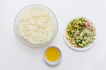 ingredients for vegetable salad, shredded cabbage, cucumbers. avocado, beans on white background