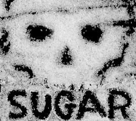 Crystals of sugar on a black background in the form of a skull. Danger of diabetes.