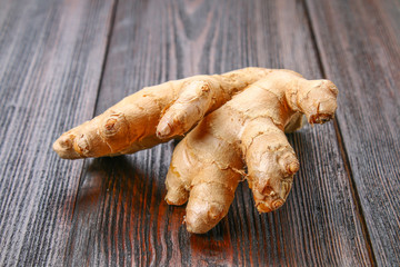 Spicy root of ginger on a wooden table.