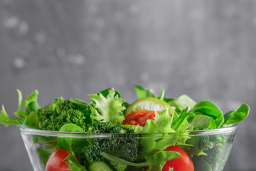 Close-up of a fresh vegetable salad over textured grey background. The concept of organic vegetarian food. Copy space.