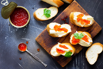 Festive snack. Sandwiches with red caviar, isolated on dark concrete background. Copy space, top view flat lay background.