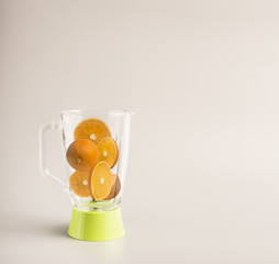 ingredients for making orange juice, sliced oranges in a green glass blender, space for text, banner