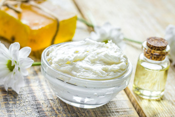 homemade cosmetics with camomile herbs on wooden background