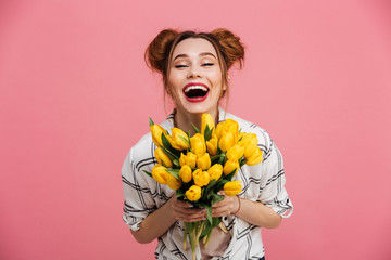 Portrait of a laughing young girl holding yellow tulips