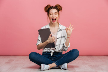 Portrait of a smiling young girl holding laptop