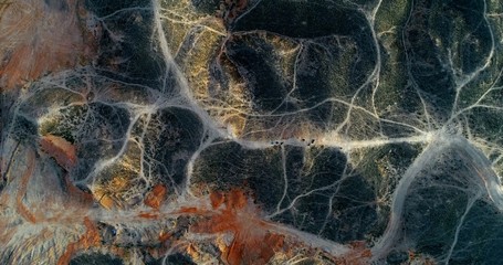 Aerial drone view on a mountainous landscape with a network of hiking paths creating amazing...