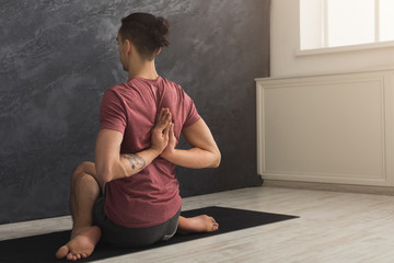 Young man practicing yoga, Reverse Prayer Pose