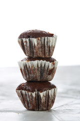 Tasty muffins arranged in pattern on light textured background, close-up, shallow depth of field, selective focus.