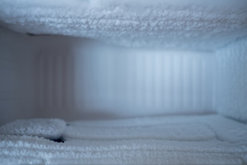 Fototapeta na wymiar Empty freezing compartment in refrigerator full of ice