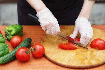 The cook cuts fresh farm vegetables