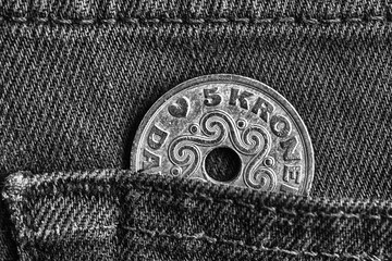 Denmark coin denomination is 5 krone (crown) in the pocket of denim jeans, monochrome shot