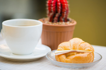 A cup of Black coffee with Ham and cheese croissant