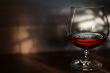 Glass of cognac on the table in the evening.