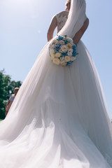 bride with wedding bouquet with blue hydrangea