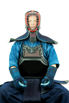 Male wearing a kendo armor with helmet and gloves, sitting position.