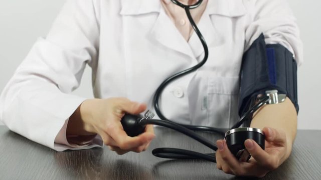 The doctor measures his blood pressure