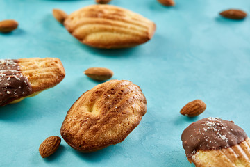 Yummy almond cookies arranged on blue background, close-up, selective focus, top view.