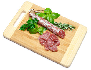 Dried sliced organic salami sausage on wooden cutting board