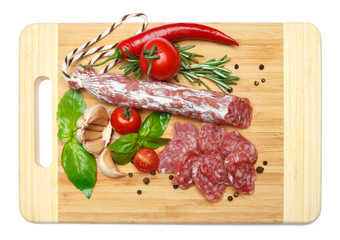 Fototapeta na wymiar Dried sliced organic salami sausage on wooden cutting board